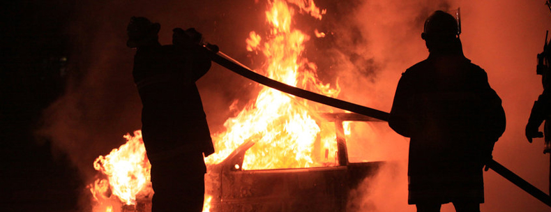 Two firefighters battling car fire