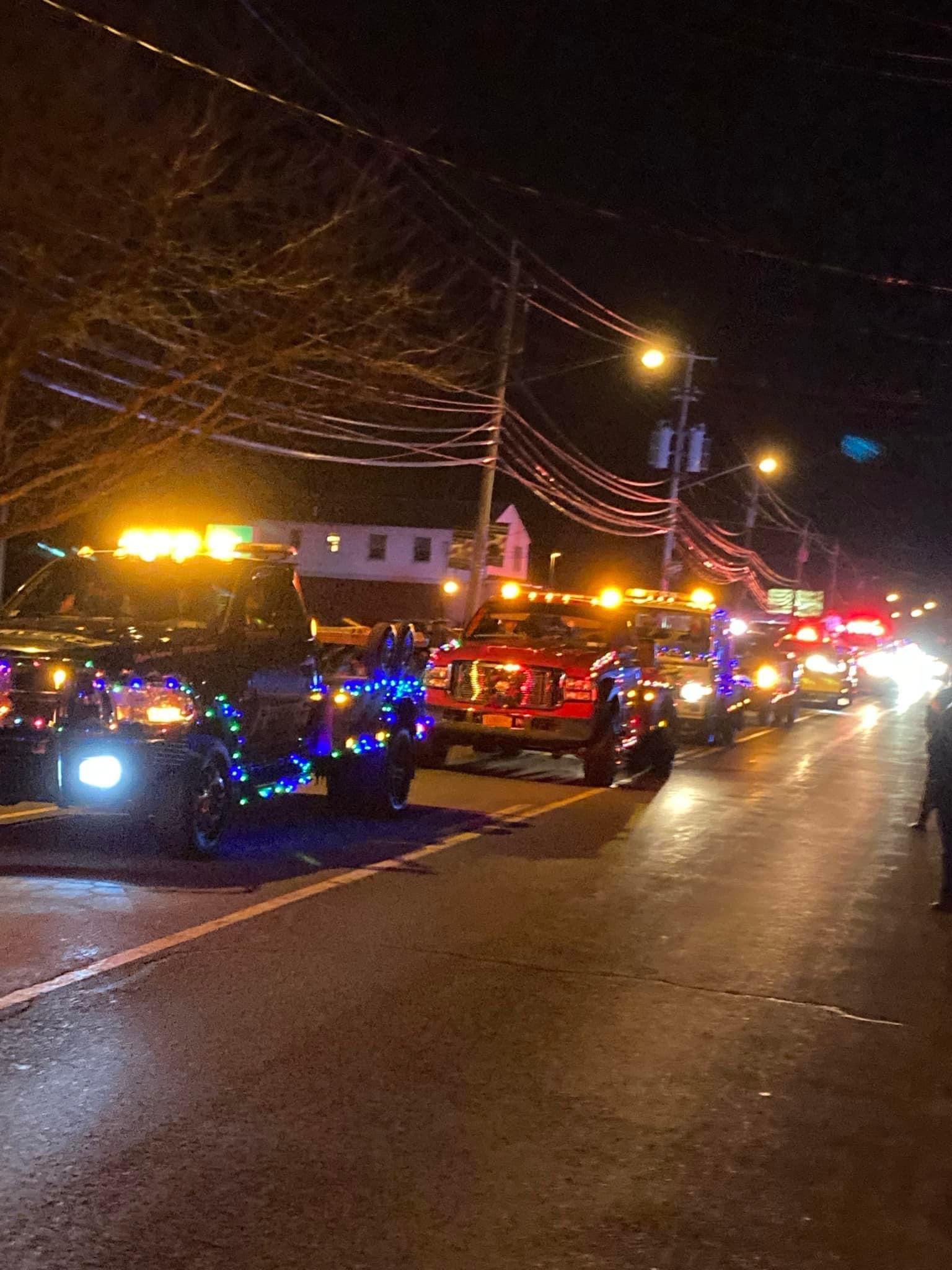 Vehicles in parade looking down street